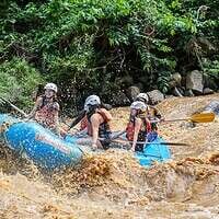 Thrilling white-water rafting adventure in a lush jungle river in Thailand.