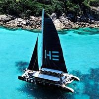 Luxury sailing yacht with black sails exploring turquoise waters in Thailand.