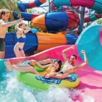 Colorful water slides with happy people enjoying a thrilling day at a water park in Thailand.