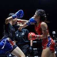 Thailand boxing match with female fighters in action.